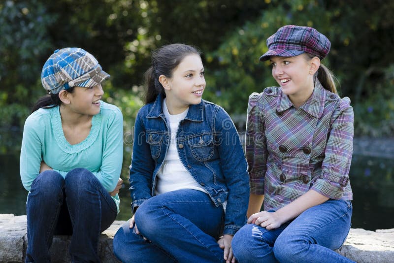 Tres muchachas sonrientes del tween al aire libre foto de archivo libre de regalías Tres muchachas sonrientes del tween al aire libre foto de archivo libre de regalías