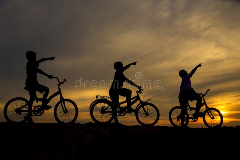 Tres muchachos que completan un ciclo a lo largo del frente foto de archivo Tres muchachos que completan un ciclo a lo largo del frente foto de archivo