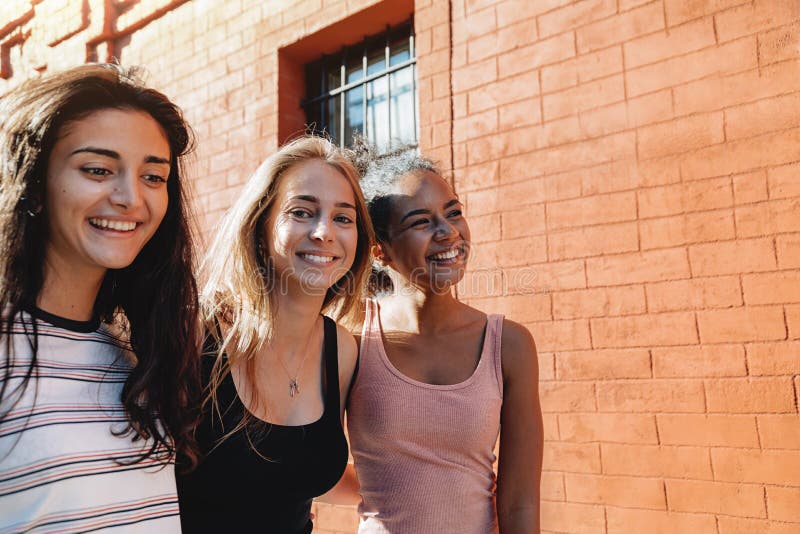 Tres mujeres alegres que caminan junto fotografía de archivo libre de regalías Tres mujeres alegres que caminan junto fotografía de archivo libre de regalías