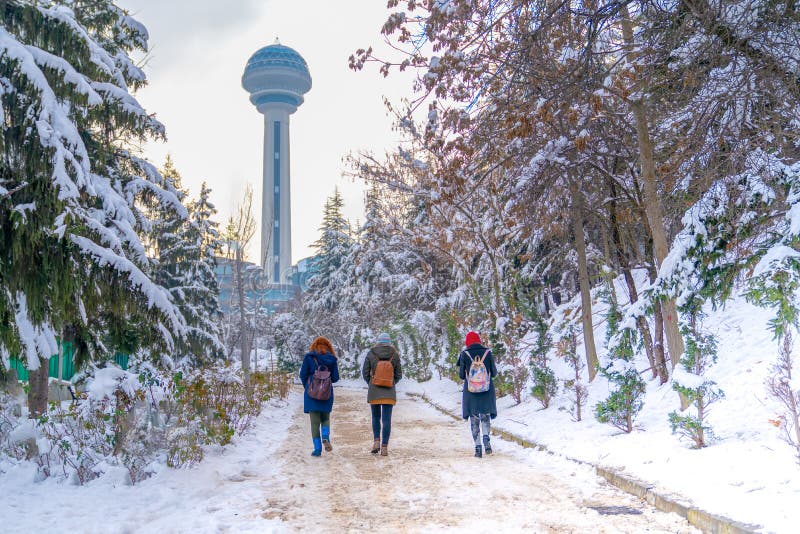 Tres mujeres caminan a Atakule a través de jardín botánico debajo de la nieve, Ankara Turquía imagen de archivo libre de regalías Tres mujeres caminan a Atakule a través de jardín botánico debajo de la nieve, Ankara Turquía imagen de archivo libre de regalías