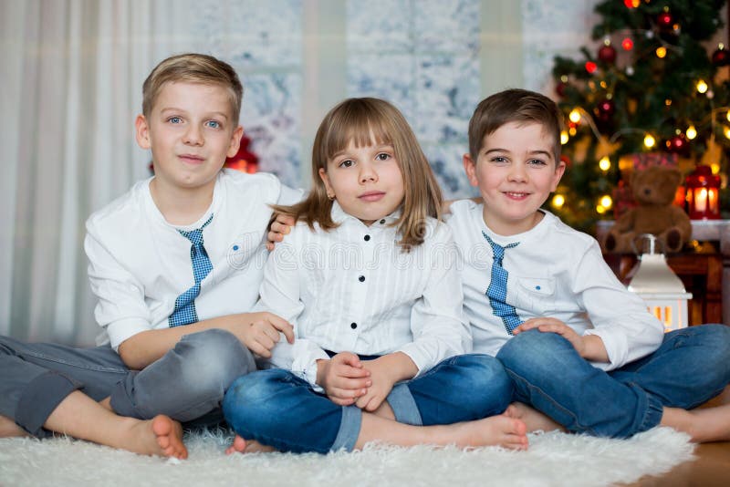 Tres niños, hermanos, teniendo su retrato de la Navidad imagen de archivo libre de regalías Tres niños, hermanos, teniendo su retrato de la Navidad imagen de archivo libre de regalías