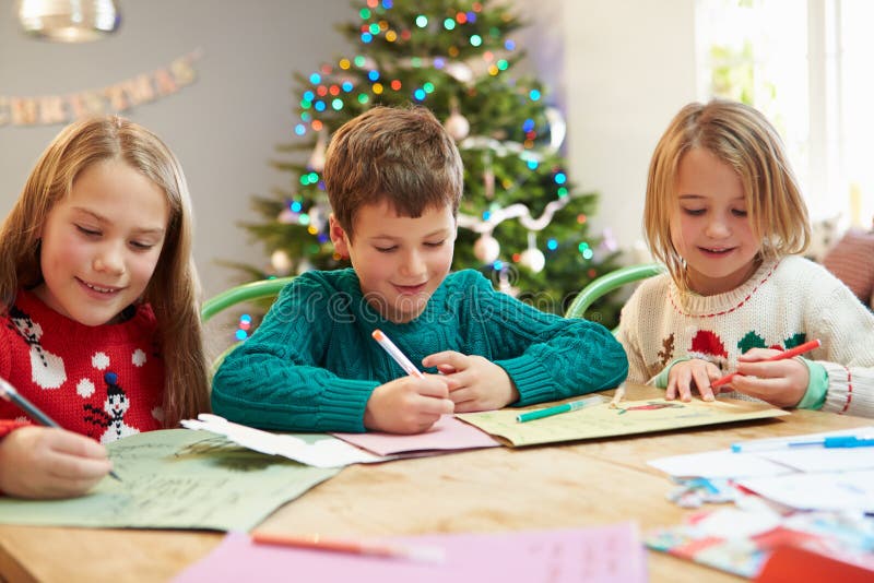 Tres niños que escriben letras a Santa Together imagenes de archivo Tres niños que escriben letras a Santa Together imagenes de archivo