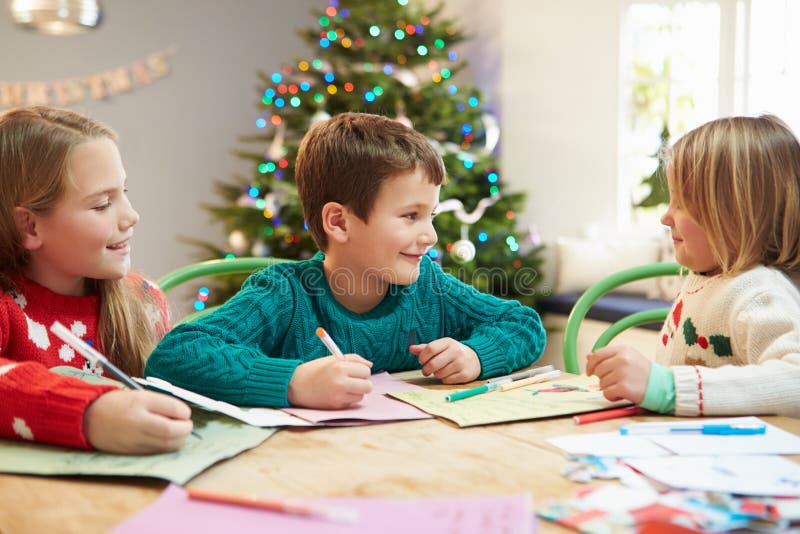Tres niños que escriben letras a Santa Together imagen de archivo libre de regalías Tres niños que escriben letras a Santa Together imagen de archivo libre de regalías
