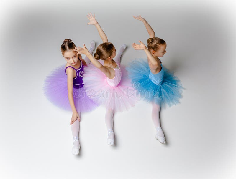 Tres pocas muchachas del ballet que se sientan en tutú y que presentan junto imagenes de archivo Tres pocas muchachas del ballet que se sientan en tutú y que presentan junto imagenes de archivo