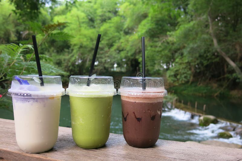 Tres vidrios de la bebida - cacao, té verde y jugo helados del coco del frappe imagen de archivo Tres vidrios de la bebida - cacao, té verde y jugo helados del coco del frappe imagen de archivo