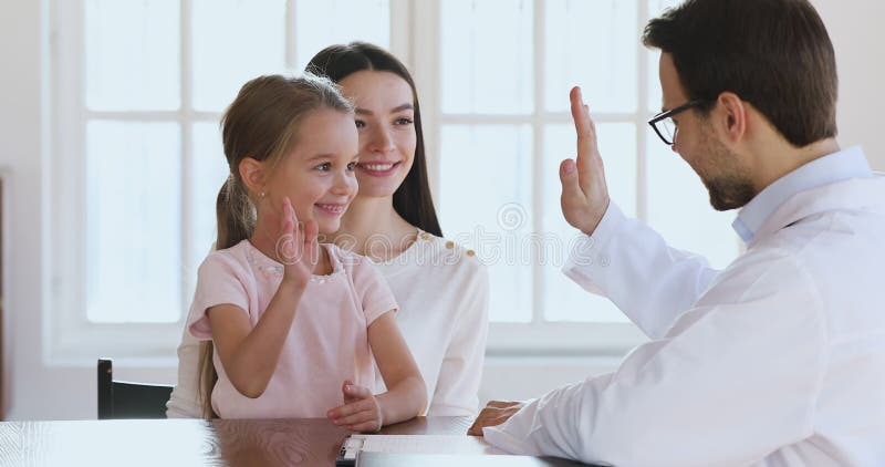 Trevlig söt liten flicka ger fem till manliga läkare