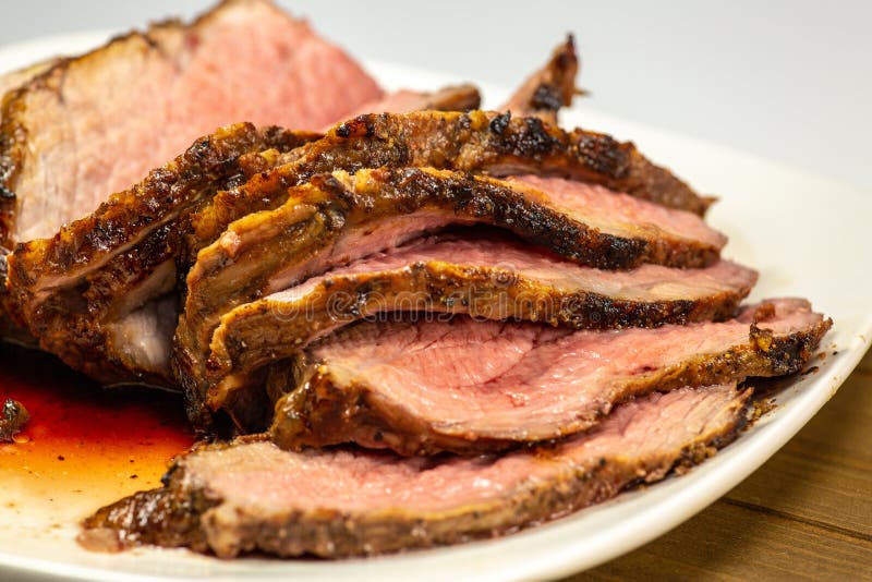 Tri filete asado a la parrilla de la extremidad cortado en una placa blanca en la tabla de cocina imagenes de archivo Tri filete asado a la parrilla de la extremidad cortado en una placa blanca en la tabla de cocina imagenes de archivo