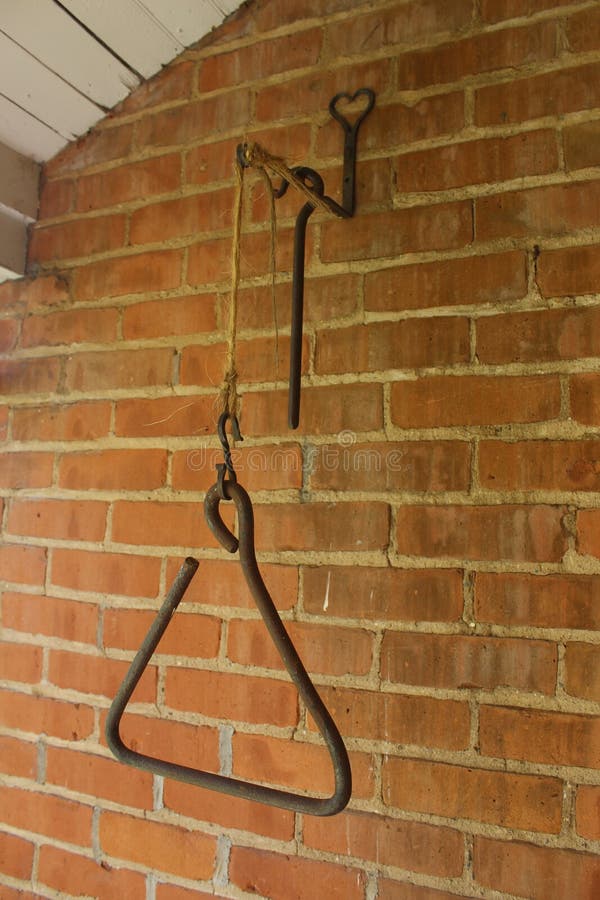 Triangle Dinner Bell Hanging on a Brick Wall Stock Image Image of