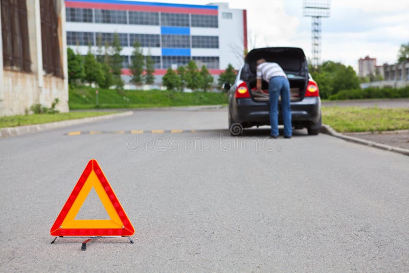 Triangle warning sign on road with driver in car