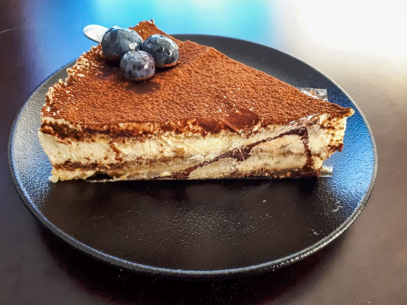 Hover do an experiment Accord Triangular Piece of Italian Dessert - Tiramisu Cake Decorated with  Blueberries on a Dark Plate on Dark Table in an Outdoor Terrace Stock Image  - Image of gastronomy, cookie: 220682205