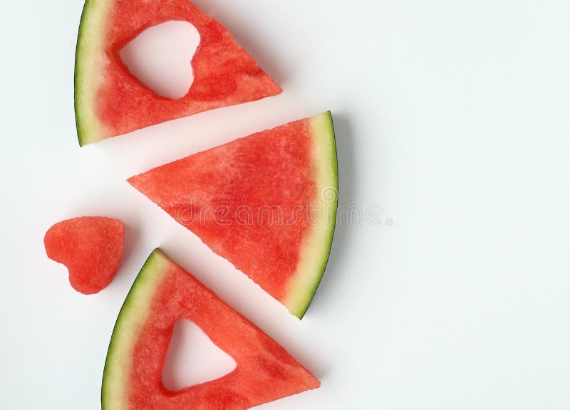 Triangular pieces of watermelon with a heart cut from the pulp of watermelon in a cup on a light background. High quality photo. Triangular cut watermelon stock images, royalty-free photos and pictures