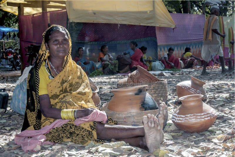 A tribal woman is waiting for somebody after buying materials from market. royalty free stock photos