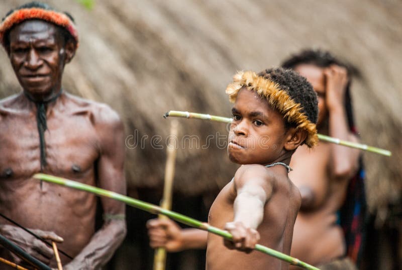 DANI VILLAGE, WAMENA, IRIAN JAYA, NEW GUINEA, INDONESIA â€“ 15 MAY 2012: Children Dani tribe learning to throw a spear. DANI VILLAGE, WAMENA, IRIAN JAYA, NEW GUINEA, INDONESIA â€“ 15 MAY 2012: Children Dani tribe learning to throw a spear.