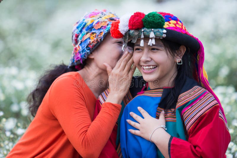 Tribu heureuse de colline de sourire chuchotant de bonnes actualités images libres de droits Tribu heureuse de colline de sourire chuchotant de bonnes actualités images libres de droits