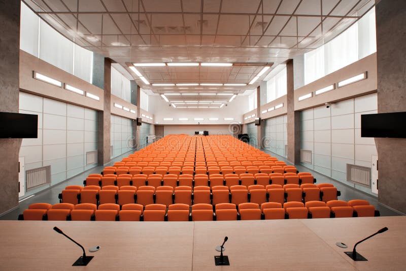Tribuna con el micrófono y el ordenador en sala de conferencias Color anaranjado foto de archivo libre de regalías Tribuna con el micrófono y el ordenador en sala de conferencias Color anaranjado foto de archivo libre de regalías
