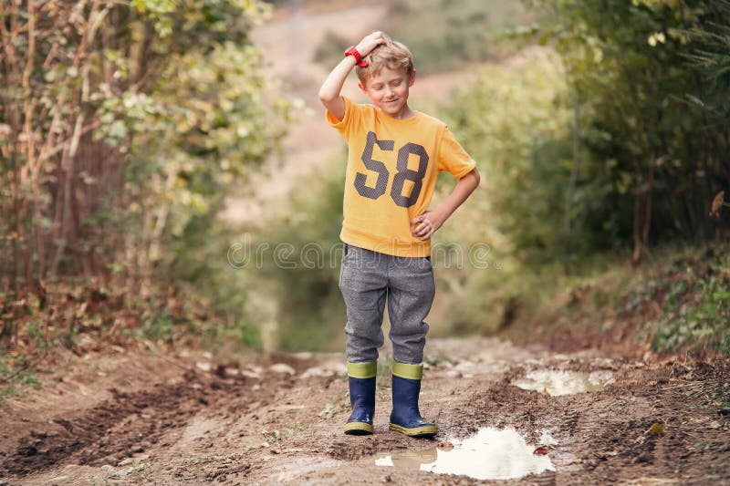 Tricky face boy near the puddle on country road