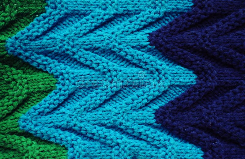 Tricottare di struttura della sciarpa o del maglione grande Fondo tricottato del jersey con un modello in rilievo Trecce dentro M fotografia stock libera da diritti Tricottare di struttura della sciarpa o del maglione grande Fondo tricottato del jersey con un modello in rilievo Trecce dentro M fotografia stock libera da diritti