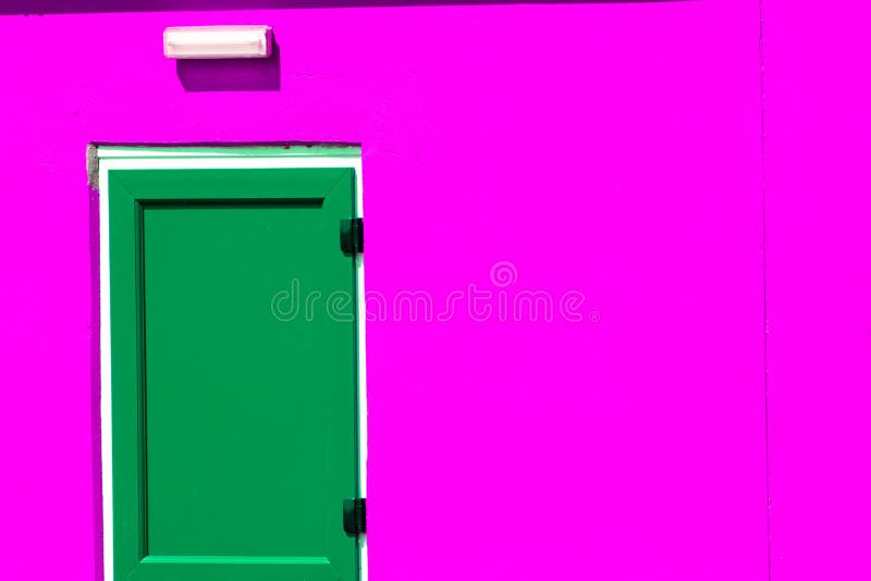Trillende kleurrijke verf Groene geschilderde deur bij de neon roze bouw stock foto Trillende kleurrijke verf Groene geschilderde deur bij de neon roze bouw stock foto