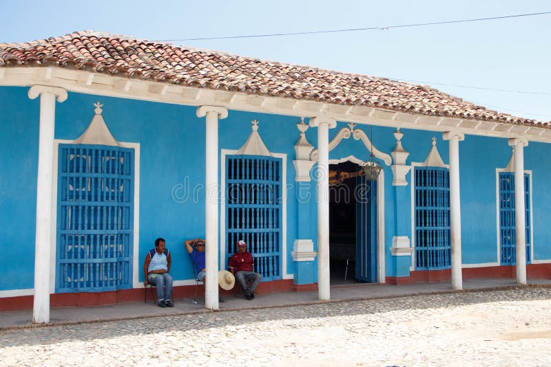 Trinidad, Cuba - mensen die voor een blauw huis zitten stock afbeelding Trinidad, Cuba - mensen die voor een blauw huis zitten stock afbeelding