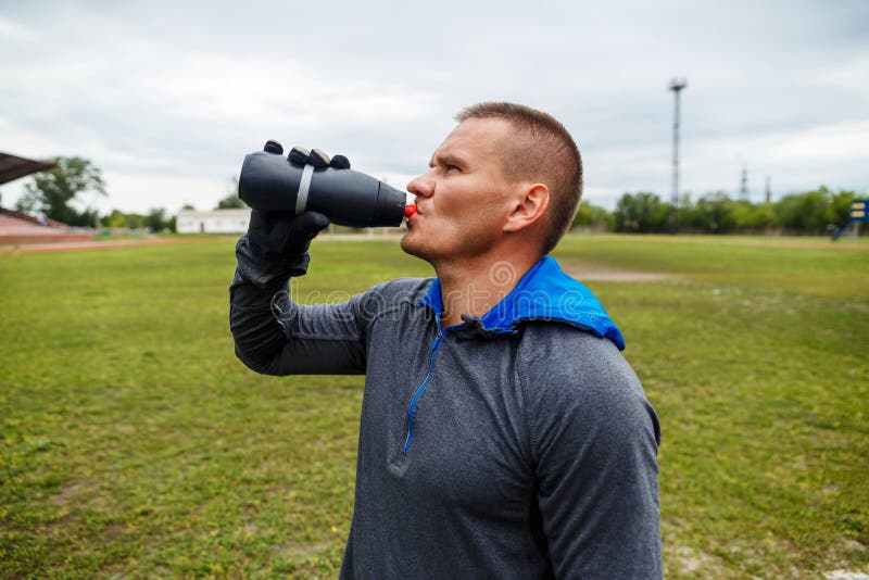 Trinkwasser des Athleten von einer Flasche lizenzfreies stockfoto Trinkwasser des Athleten von einer Flasche lizenzfreies stockfoto