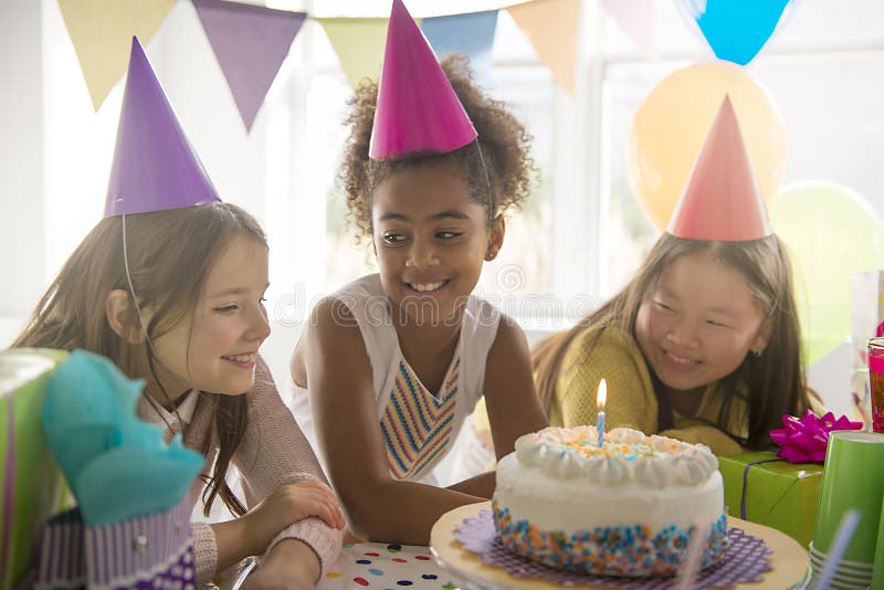 Trio aanbiddelijke jonge geitjes die pret hebben bij verjaardagspartij royalty-vrije stock afbeelding Trio aanbiddelijke jonge geitjes die pret hebben bij verjaardagspartij royalty-vrije stock afbeelding