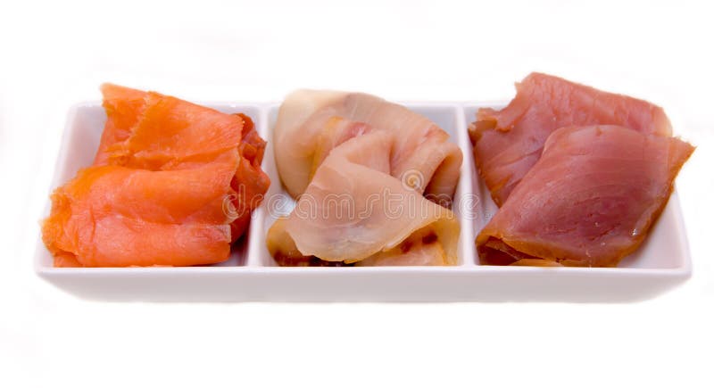 Trio of smoked fish on platter over white background. Trio of smoked fish on platter over white background