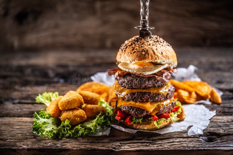 triple-beef-burger-sunny-side-up-egg-cheese-nuggets-side-dark-wooden-surroundings-triple-beef-burger-sunny-187133509.jpg