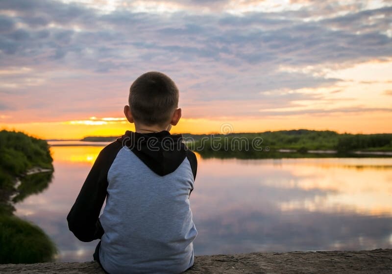 Menino triste sozinho no pôr do sol