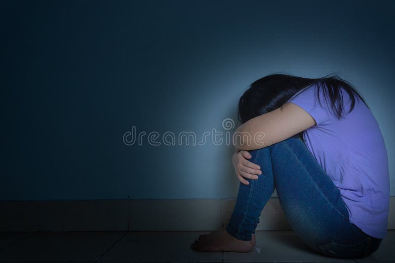 A mulher com depressão abraça o joelho e chora. a mulher triste