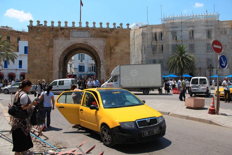 TUNISIA, TUNIS, JUNE 30, 2010: Downtown in Tunis, Tunisia. People near triumphal arch. The triumphal arch at the end of the boulevard at the entrance to the medina. TUNISIA, TUNIS, JUNE 30, 2010: Downtown in Tunis, Tunisia. People near triumphal arch. The triumphal arch at the end of the boulevard at the entrance to the medina.