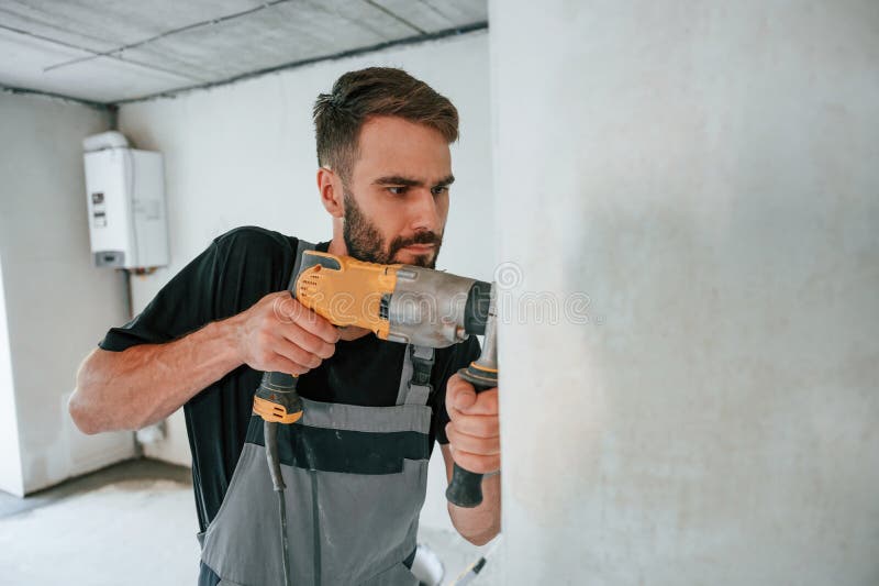 Trivellazione nel muro. l'uomo sta riparando nell'appartamento immagini stock libere da diritti