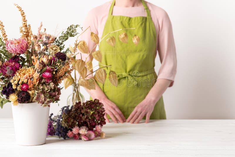 Trockenblumen. Blumenweibchen, die getrocknete Blumen zu einem schönen Bouquet arrangieren. nachhaltige Blüte. stockfoto