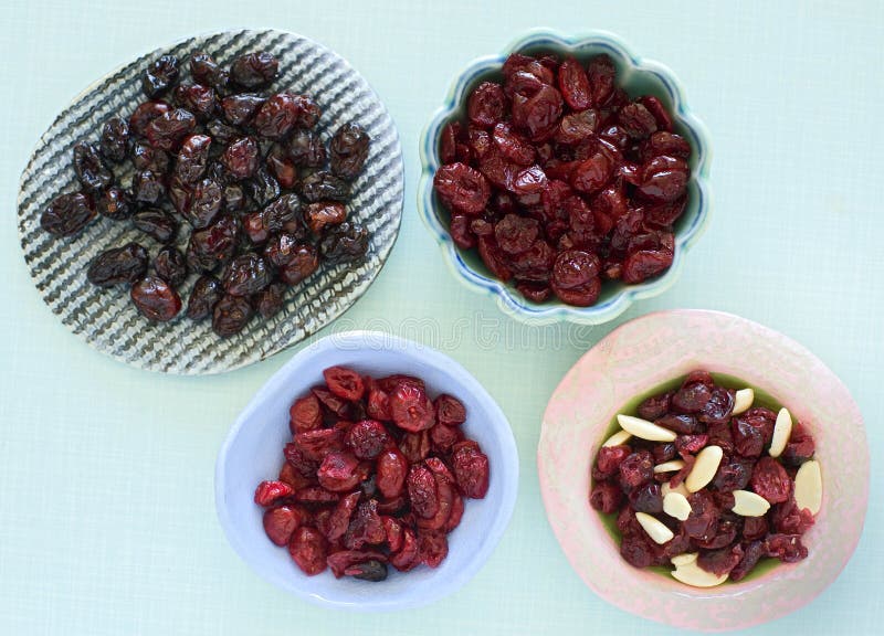 Assorted dry cranberries in small ceramic bowls. Assorted dry cranberries in small ceramic bowls