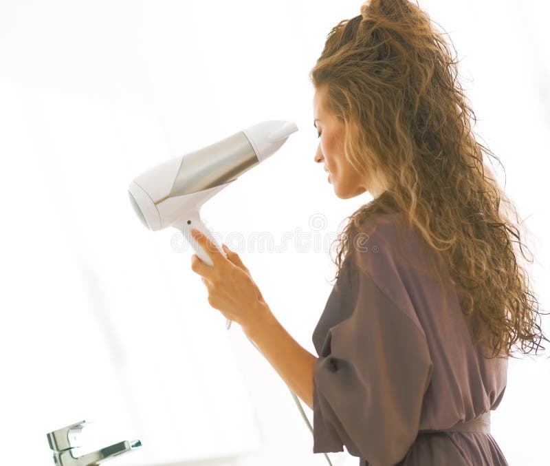 Trocknendes Haar des Schlages der jungen Frau im Badezimmer stockbild Trocknendes Haar des Schlages der jungen Frau im Badezimmer stockbild