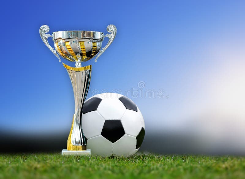 Trofeo e pallone da calcio dorati in erba immagini stock libere da diritti