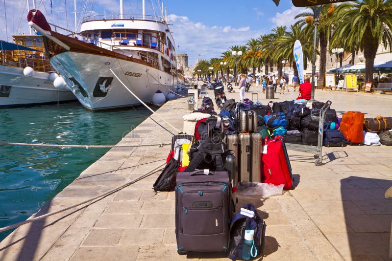 TROGIR, CROATIA. Touristic cruise ship is moored on the quayside of Trogir sea promenade with the passenger baggages ready to be brought on bord. TROGIR, CROATIA. Touristic cruise ship is moored on the quayside of Trogir sea promenade with the passenger baggages ready to be brought on bord