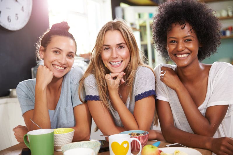 Trois amis féminins appréciant le petit déjeuner à la maison ensemble photos libres de droits Trois amis féminins appréciant le petit déjeuner à la maison ensemble photos libres de droits