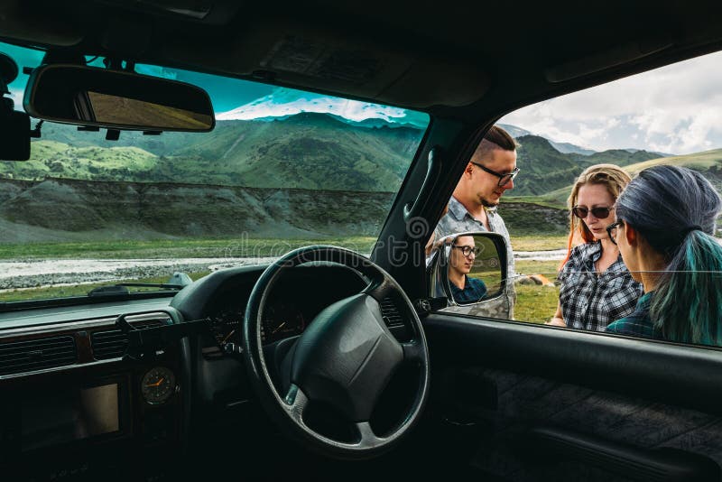 Trois amis près de la voiture discutent l'itinéraire dans le voyage photos libres de droits Trois amis près de la voiture discutent l'itinéraire dans le voyage photos libres de droits