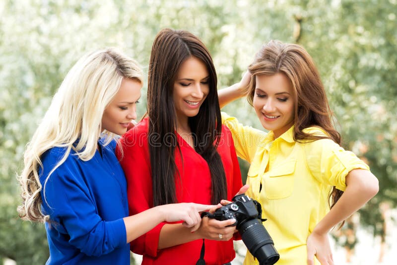 Trois belles femmes ayant un photosession dans le parc photo stock Trois belles femmes ayant un photosession dans le parc photo stock