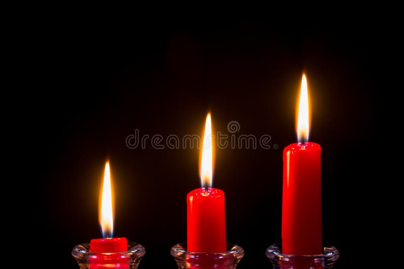 Trois bougies rouges sur un fond noir image stock Trois bougies rouges sur un fond noir image stock