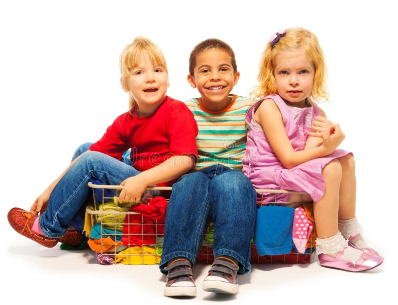 Trois enfants s'asseyant dans le panier à linge photo libre de droits Trois enfants s'asseyant dans le panier à linge photo libre de droits
