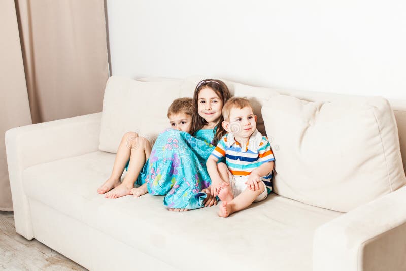 Trois enfants sont séance photographiée sur le divan photo libre de droits Trois enfants sont séance photographiée sur le divan photo libre de droits