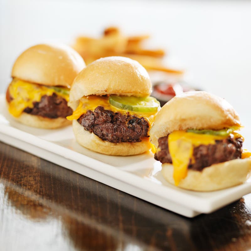 Trois glisseurs d'hamburger avec du fromage et des conserves au vinaigre photos libres de droits Trois glisseurs d'hamburger avec du fromage et des conserves au vinaigre photos libres de droits