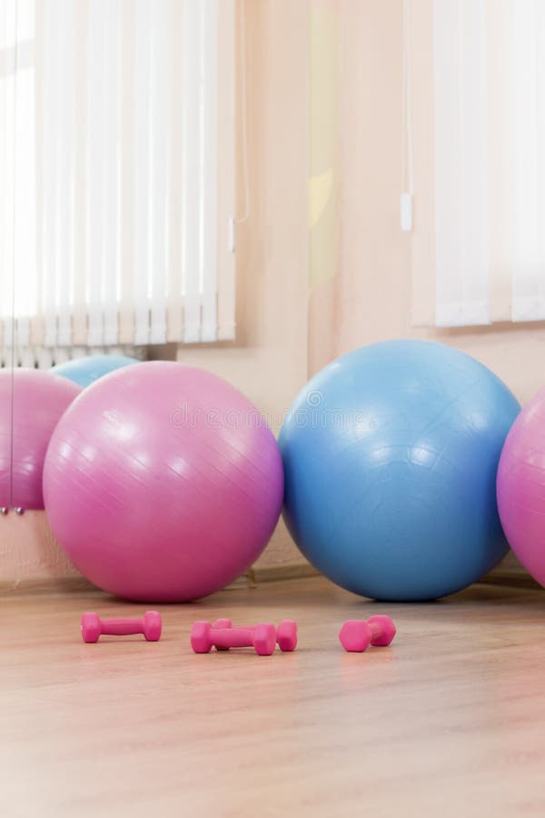 Trois grand Fitballs avec des Barbells sur le plancher au centre de fitness de sport à l'intérieur images libres de droits Trois grand Fitballs avec des Barbells sur le plancher au centre de fitness de sport à l'intérieur images libres de droits
