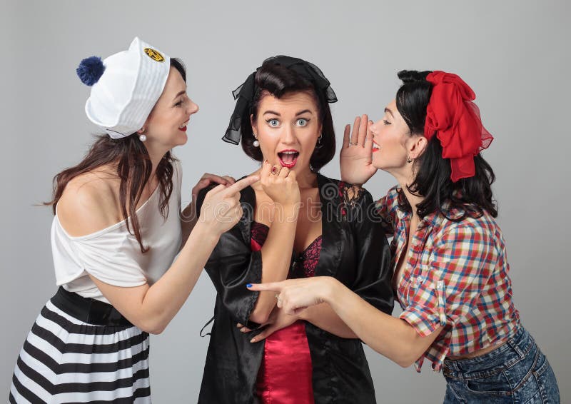 Trois jeunes femmes chuchotant le bavardage images stock Trois jeunes femmes chuchotant le bavardage images stock
