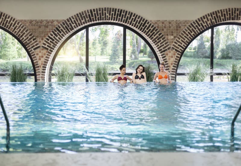 Trois jeunes femmes dans la piscine image stock Trois jeunes femmes dans la piscine image stock