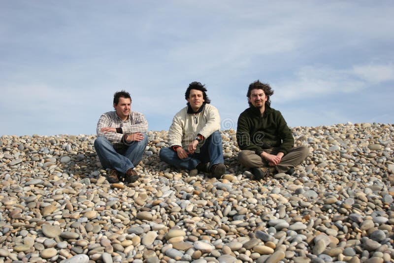 Trois jeunes hommes occasionnels à la plage photo stock Trois jeunes hommes occasionnels à la plage photo stock