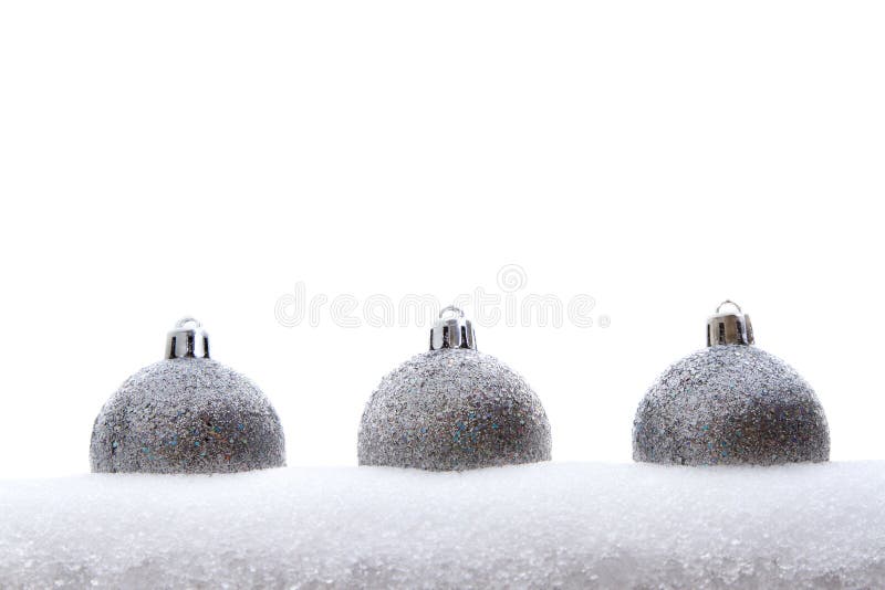Trois ornements argentés de Noël de scintillement dans la neige images libres de droits Trois ornements argentés de Noël de scintillement dans la neige images libres de droits