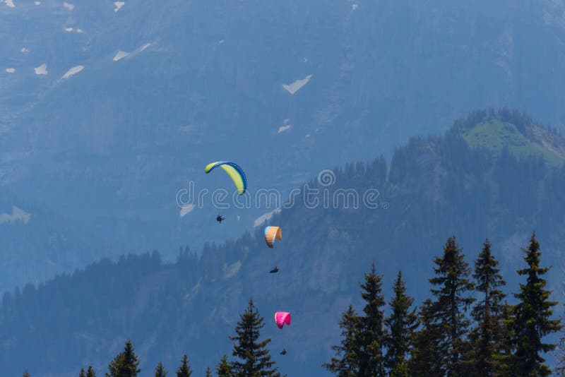 Trois parapentistes volant dans les montagnes images libres de droits Trois parapentistes volant dans les montagnes images libres de droits