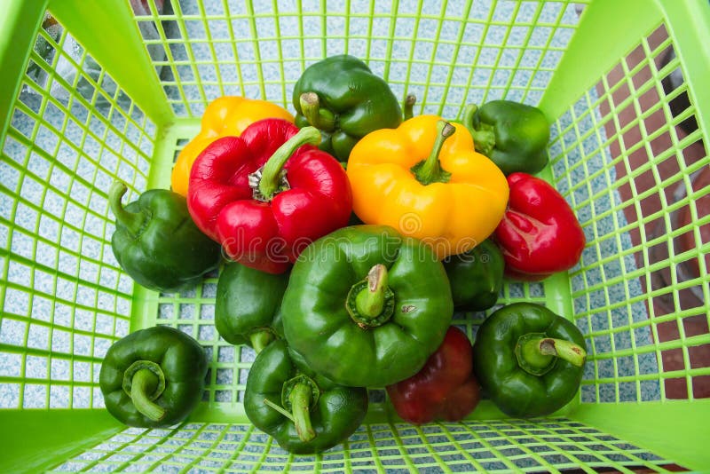 Trois poivrons doux de couleurs dans un panier sur le marché images libres de droits Trois poivrons doux de couleurs dans un panier sur le marché images libres de droits